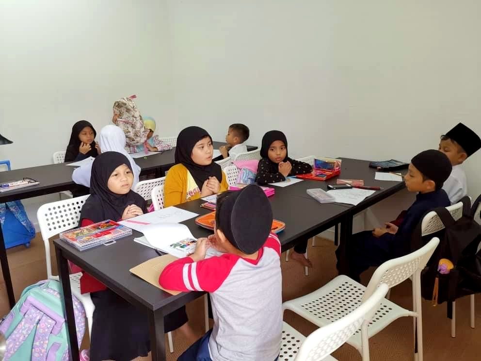 Murid menulis di dalam kelas