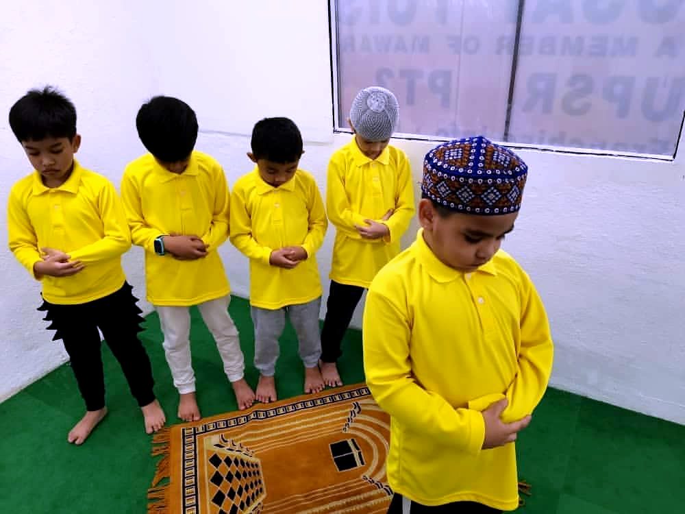 Murid berbaju kuning bersolat
